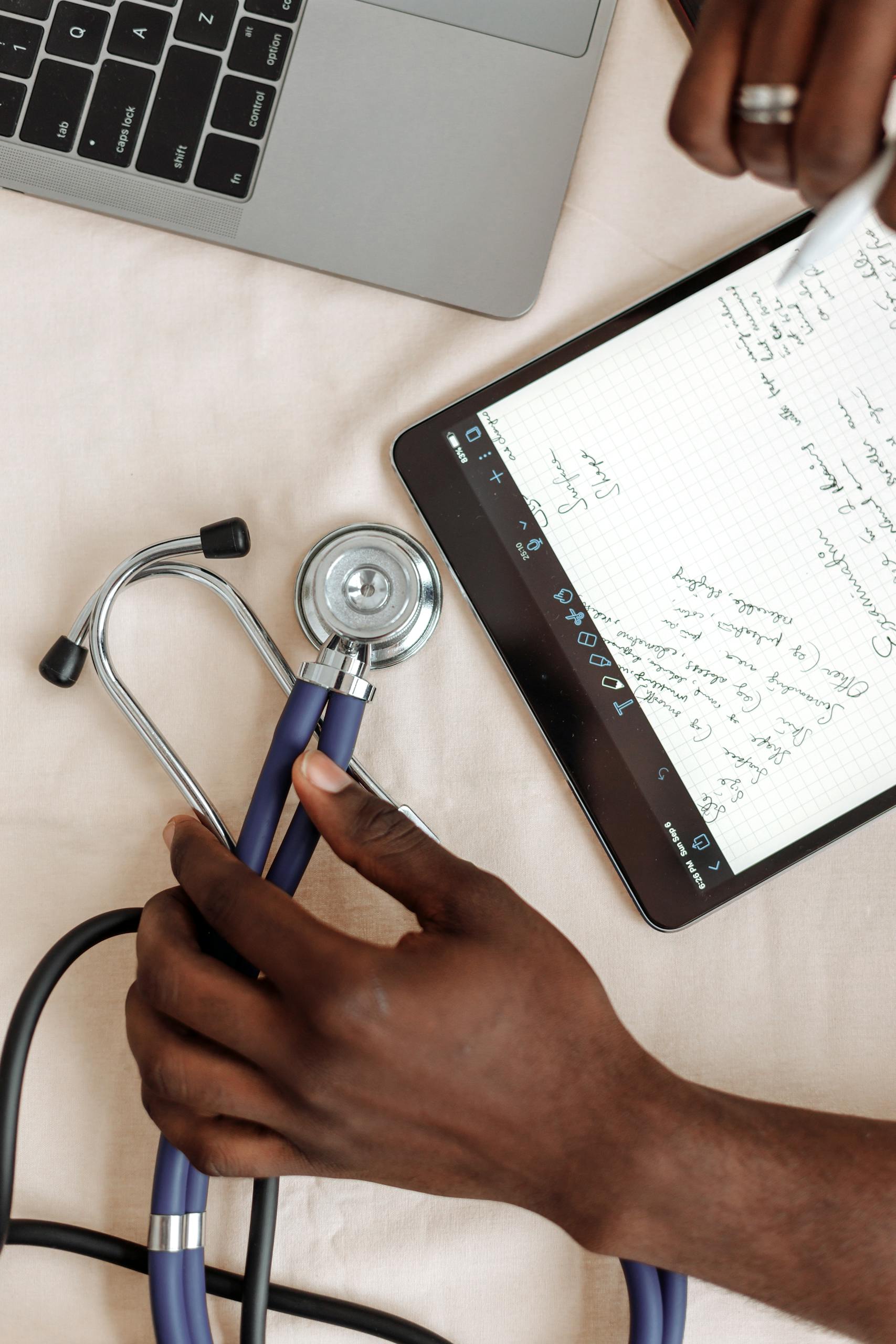 Close-up of hands with stethoscope and tablet notes for Residency Match ERAS preparation
